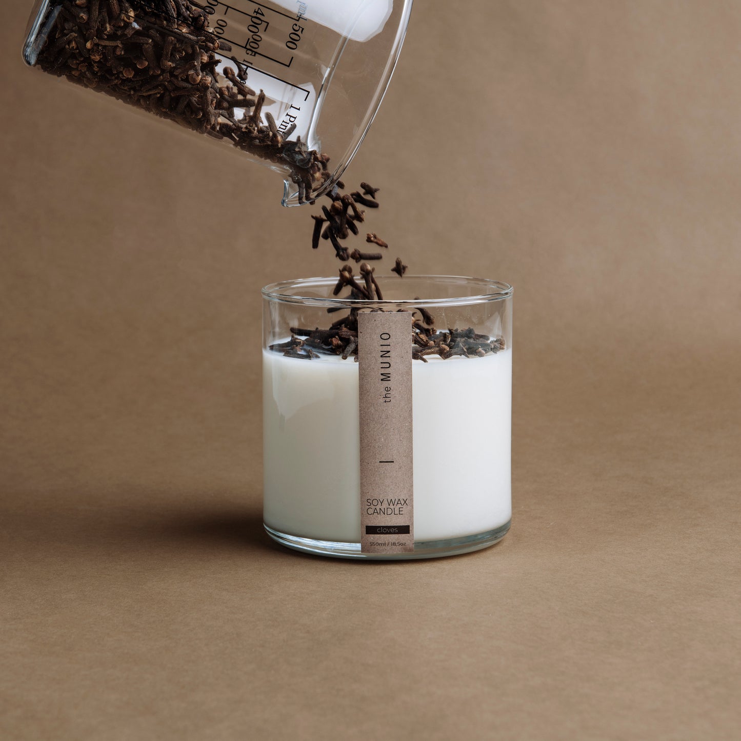 Krustnagliņu un apelsīna svece stikla traukā