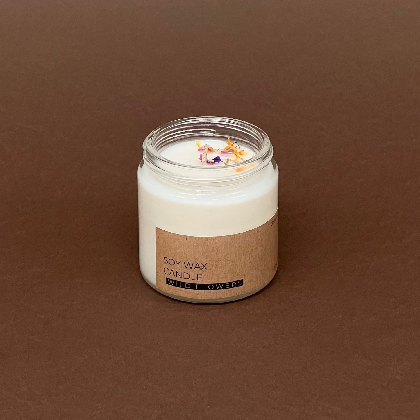 Pļavas ziedu mazā svece stikla traukā