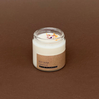 Pļavas ziedu mazā svece stikla traukā