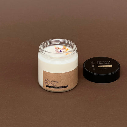 Pļavas ziedu mazā svece stikla traukā